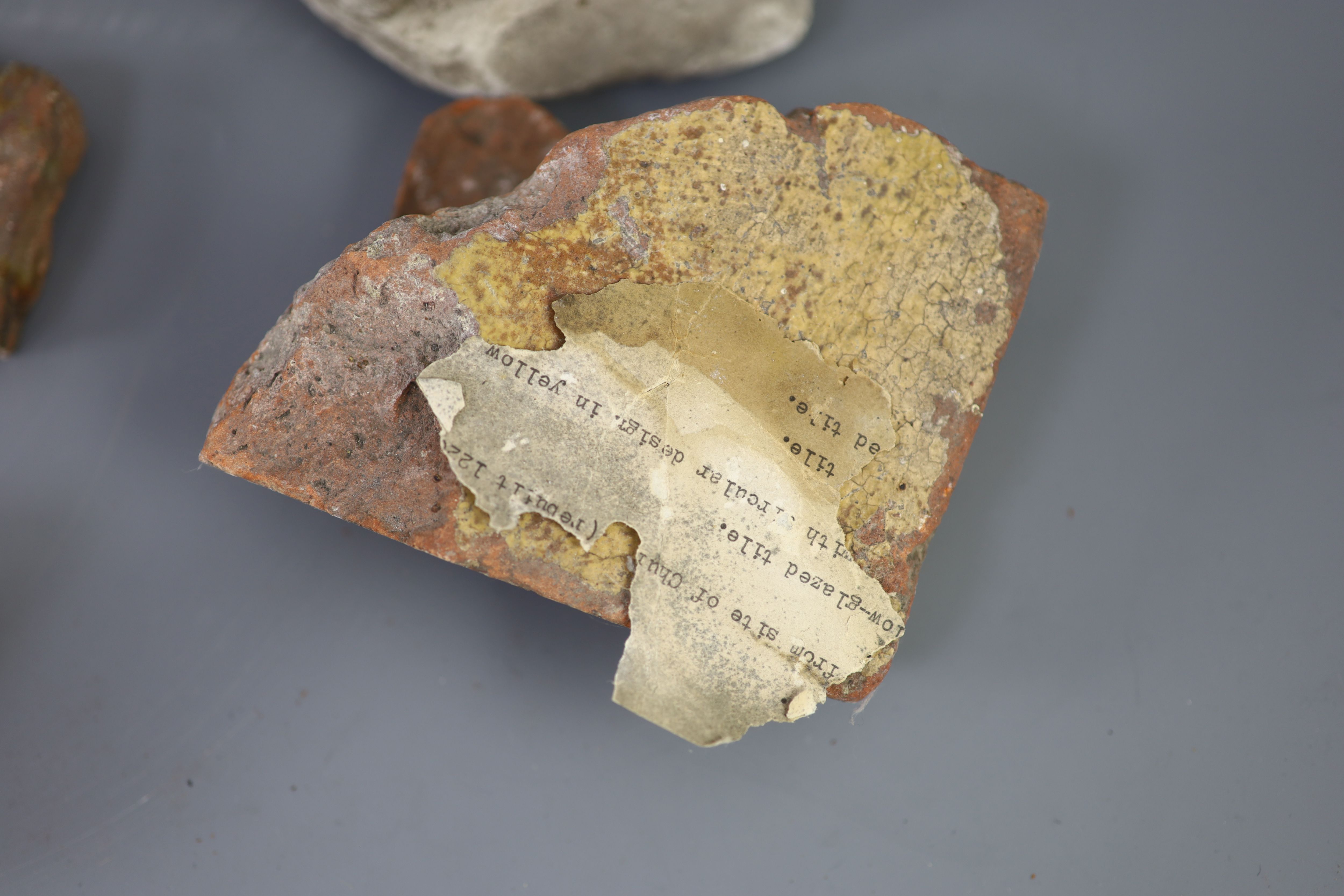 A group of English medieval church/priory architectural stonework and tile fragments, some pieces with inscribed labels of provenance,